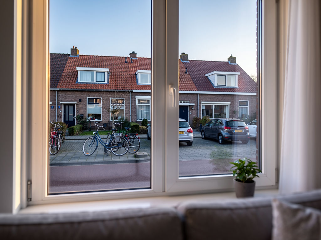 Doorkijk door PVC kozijn naar straat in Enschede